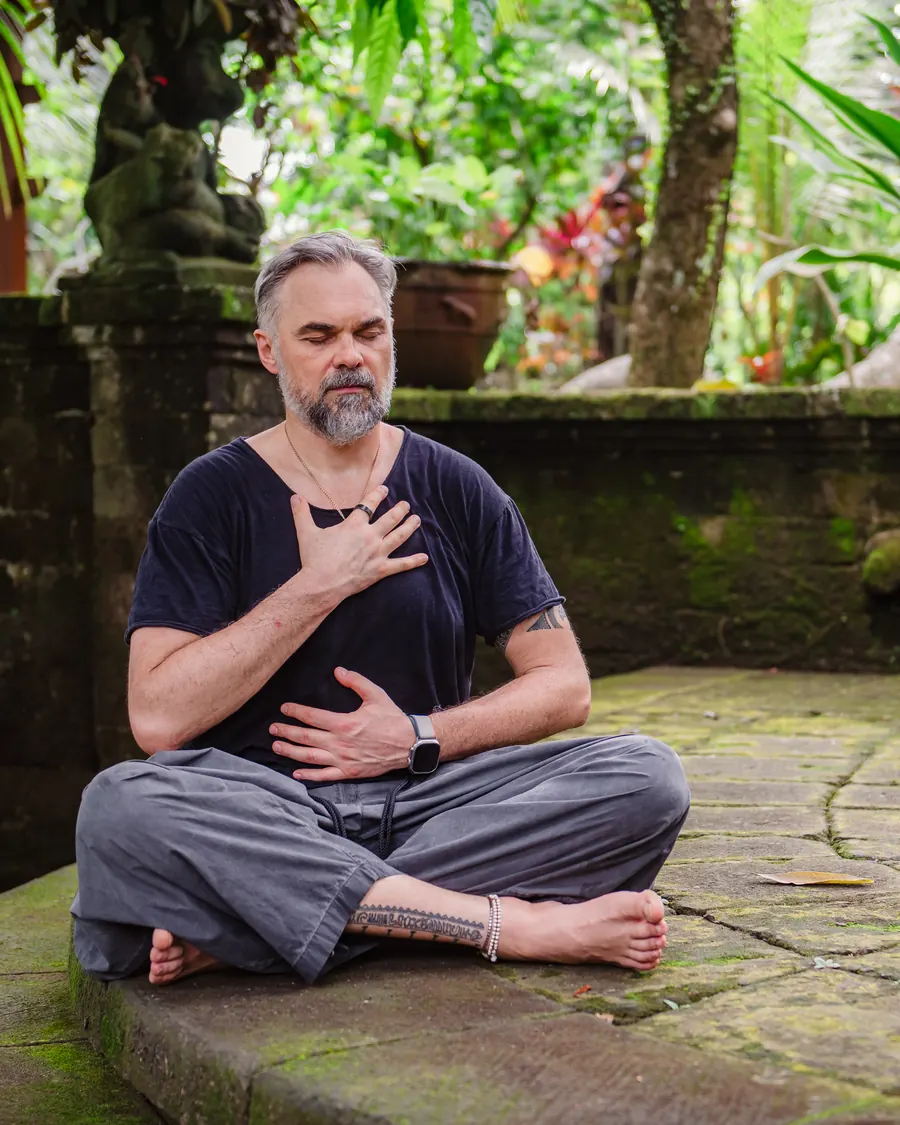 Nisarga breathing with one hand on his heart and one on his belly